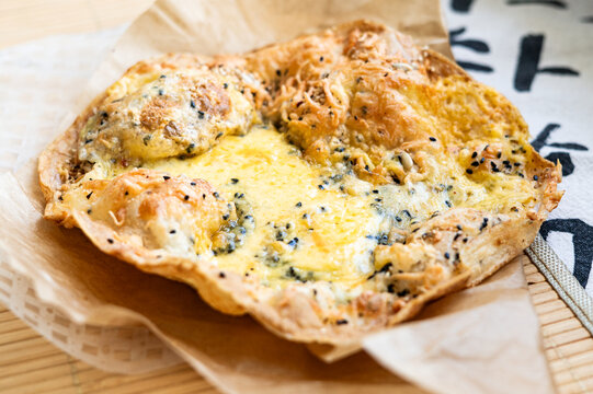 Crispy rice paper with melted cheese black cumin and sesame seeds