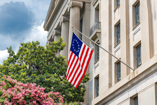 Historic Federal Building With American Flag And Flowering Trees In Washington DC Spring Season