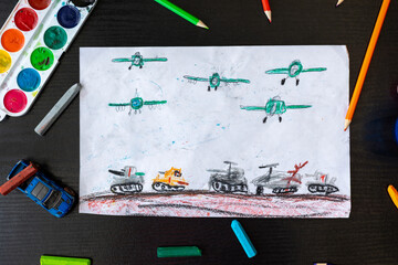 Fototapeta premium Child's drawing depicting war and military vehicles. Concept of childhood during armed conflict, emotional expression and children's mental health