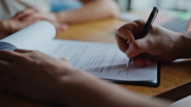 Closeup hands signing business contract document. Women handshake office deal.
