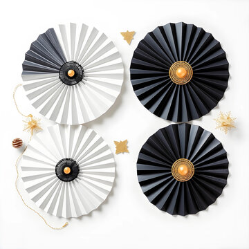 Black and white paper fan decorations with gold accents and festive ornaments on a clean background, this elegant display features a minimalist design