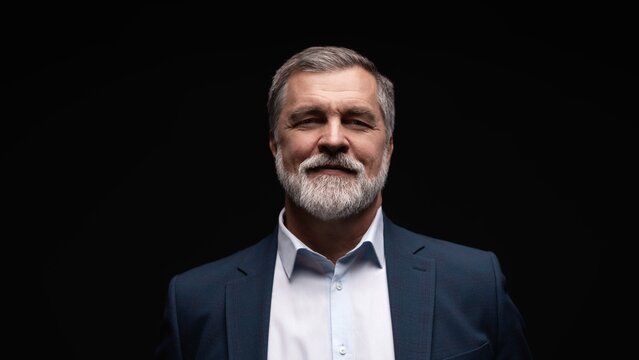 Studio portrait of senior businessman in suit on dark background