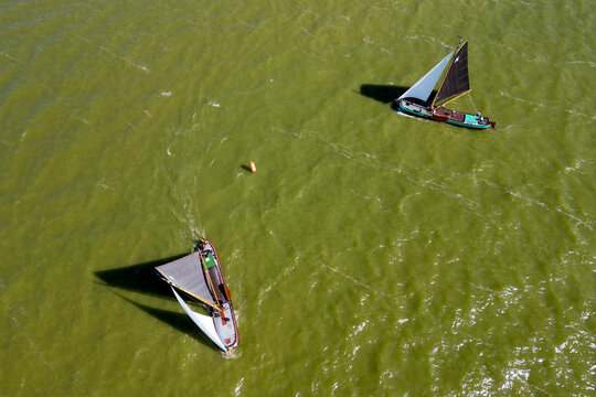 STAVOREN, THE NETHERLANDS AUGUST 12, 2023: Traditional Skutsjes Compete During the Annual SKS Skutsjesilen Sailing Championship on the IJsselmeer
