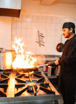 Professional chef flamb ing food creating impressive flame