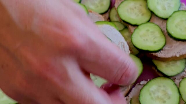 Open faced sandwiches with liver paste and fresh cucumber slices served on pink plate
