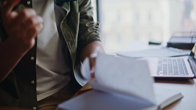 Businessman talking smartphone taking notes. Freelancer working laptop closeup