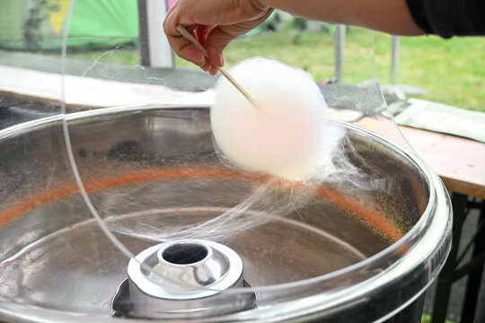 Making cotton candy in a pot with centrifuge and heating coil, threads are spun from sugar crystals or isomalt and wound up, selected focus
