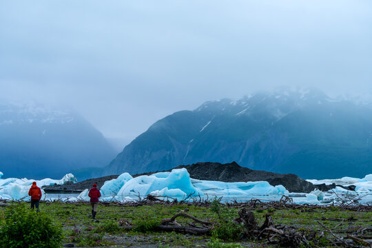 Two travelers by Alsek Lake and its icebergs