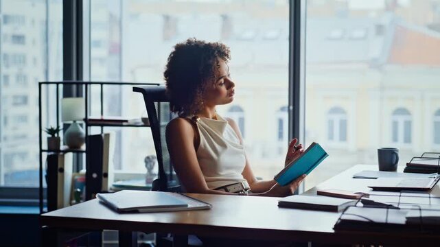 Businesswoman thinking daydreaming office desk. Pensive woman reading notebook