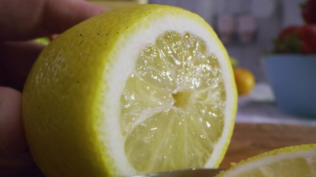 Sharp knife slicing through juicy lemon, extra closeup shot