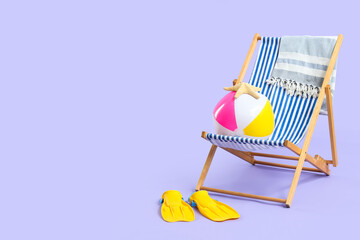 Beach chair with striped towel, colorful beach ball, starfish, and yellow flippers on a light purple background © Pixel-Shot