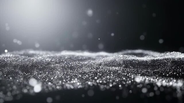Close-up of shimmering silver particles with bokeh light effect