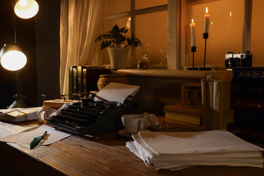 Authors workplace with vintage typewriter, coffee cup and crumpled paper in dark office