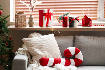 Obraz premium Burning candles with Christmas gift on shelf in living room