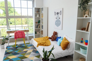 Interior of childrens room with bed, study table and bookshelves © Pixel-Shot