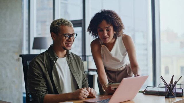 Happy couple celebrating success laptop office. Woman embracing man work place.