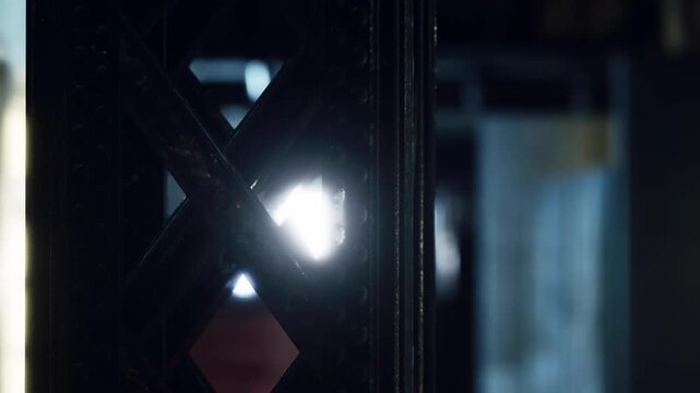 A small triangle of light comes through an opening in a dark section of a building. The light reveals patterns in the nearby materials. Shadows are visible on the walls.