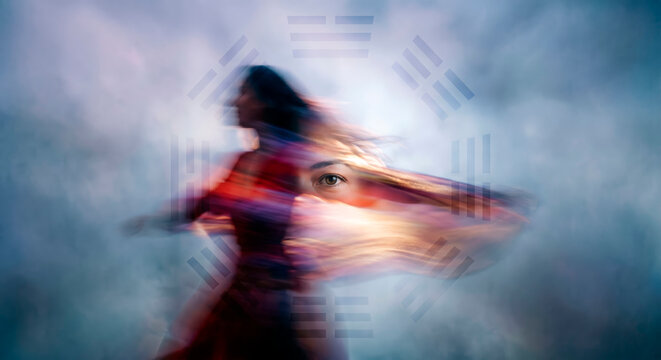 Blurred woman in flowing dress twirling in motion against a hazy blue background with a faint mystical symbol, ethereal spiritual transformation, copy space