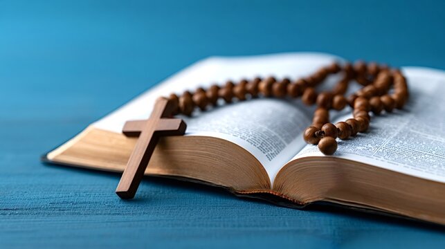 Open bible resting on a blue wooden surface with a rosary and a wooden cross emphasizing spiritual contemplation, christian faith, and daily prayer practices