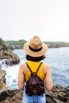 Woman exploring coastal cliffs watching ocean view
