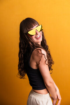 Young woman dancing with trendy yellow sunglasses