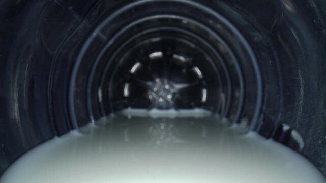 Camera enters a plastic milk bottle, revealing the white liquid surface.