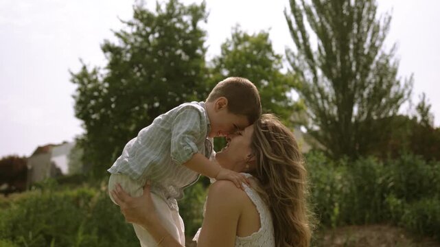 Loving mother and son hugging and playing in the park