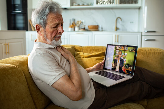 Senior man with chest pain during telehealth video call at home