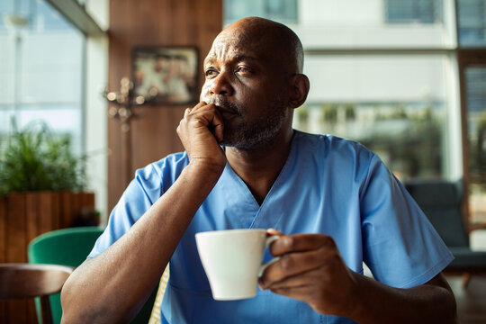 Tired healthcare worker drinking coffee in hospital break room