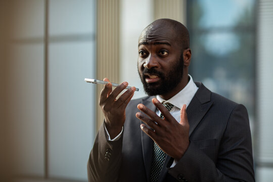 Business professional speaking into smartphone in office lobby