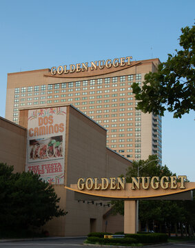  Exterior view of the Golden Nugget hotel and casino in Atlantic City featuring a large illuminated marquee,, high-rise windows and street-level trees that evoke urban leisure and entertainment