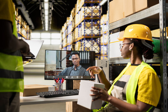 An African American woman meets with her boss on a video conference call, supporting e-commerce operations and online order processing.