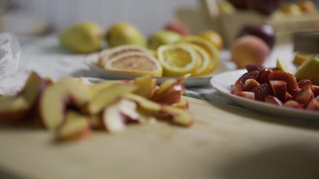 Peach slices being pushed off cutting board by knife onto another board - slow motion closeup shot