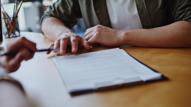 Closeup hands signing contract office. Young man reviewing agreement meeting.