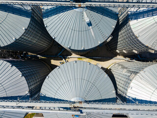 View of large grain silos during daytime at a farming site with blue sky and scattered clouds © DSMT