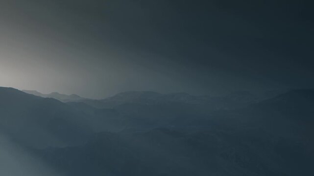 Fog blankets the mountain ranges early in the morning. The landscape shows various layers of mountains fading into the distance. The light gradually brightens the scene.