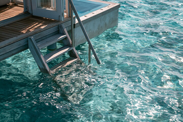 Obraz premium Overwater villa with a ladder and rippling turquoise water