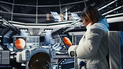 An astronaut checks mission analytics on a tablet after leaving the Mars surface  the cosmonaut enters navigation coordinates for the journey home. © DC Studio