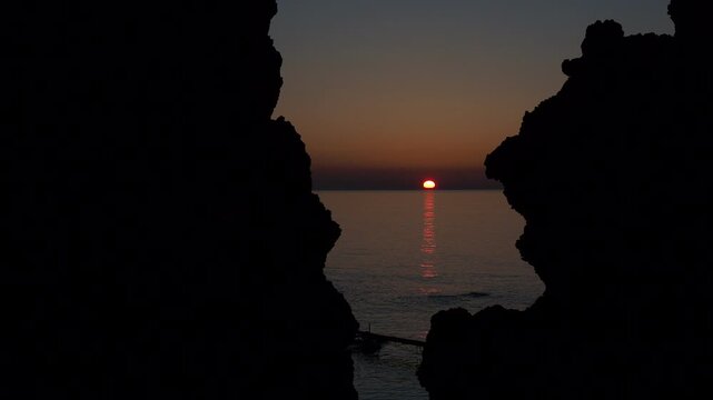 ウトロの海岸線の奇岩の間に沈む夕陽