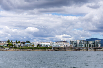 Obraz premium Cloudy Waterfront Skyline in Sidney, Vancouver Island, BC, Canada With Residential Buildings and Pier