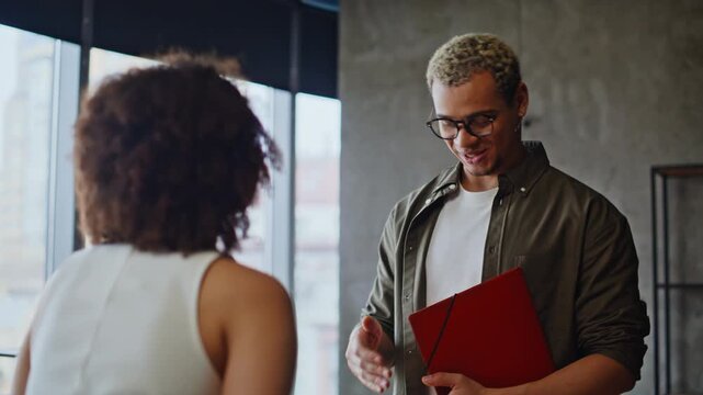 Businessman explaining documents to woman in office, consultant discussing deal