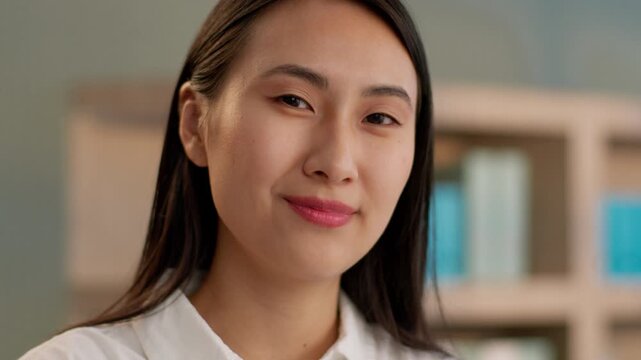 Portrait smiling Japanese Chinese woman looking at camera nodding head approve close up businesswoman Asian girl worker happy Korean business female employee friendly yes indoors agreement good sign