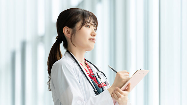 医療記録を確認する女性医療スタッフ, Female Medical Professional Reviewing Medical Records