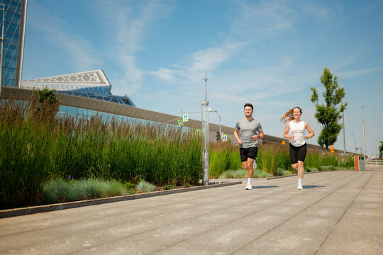 Joggers enjoy a sunny day in a vibrant urban park, embracing fitness and nature in perfect harmony