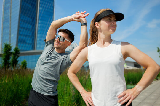Morning workout brings energy and joy as friends stretch in a sunny urban park