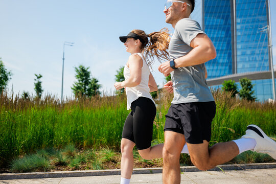 Joyful morning joggers in the city park embrace fitness and nature under a bright sun