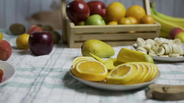 Plate of sliced oranges surrounded by other delicious fruit - tracking shot