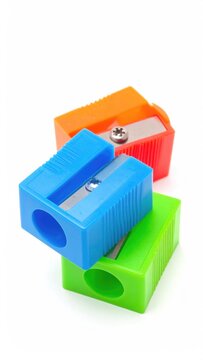 Three colorful pencil sharpeners stacked on a white background