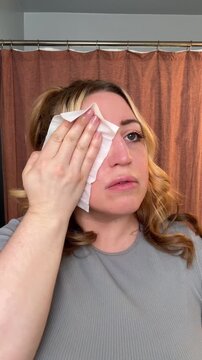 woman removes makeup from half of face with a makeup wipe