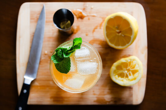 Top view of a lemonade drink with lemons and mint on a cutting board, summer